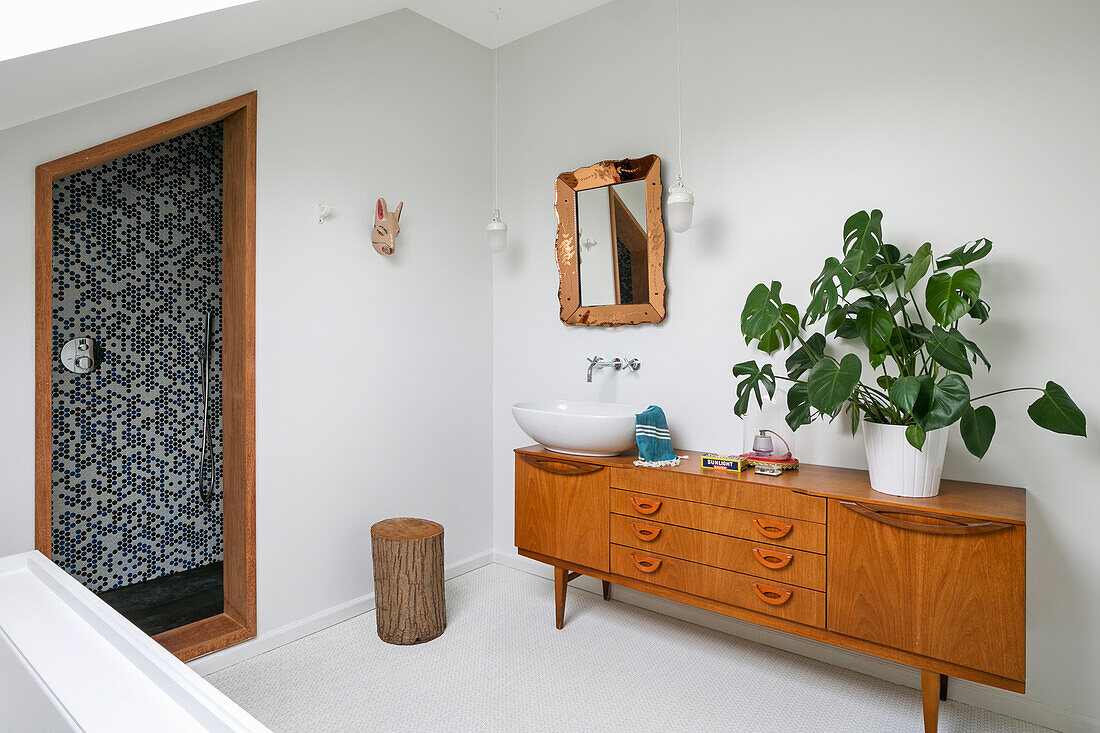 Retro sideboard used as washstand and houseplant in bathroom