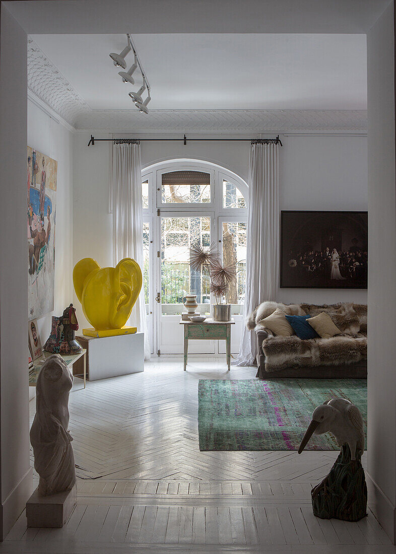 Looking into the living room with an ear sculpture in front of a balcony door