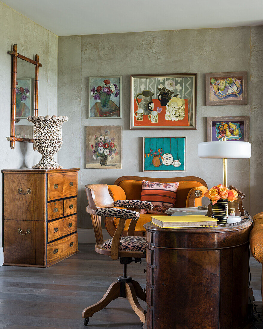 Stuhl mit Leopardenmuster an antikem Schreibtisch und gerahmte Kunstwerke im Wohnzimmer