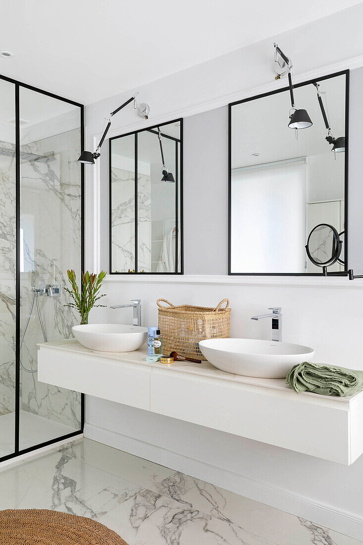 Elegantes Badezimmer mit Waschtisch, Doppelwaschbecken, Wandspiegeln und Marmorboden