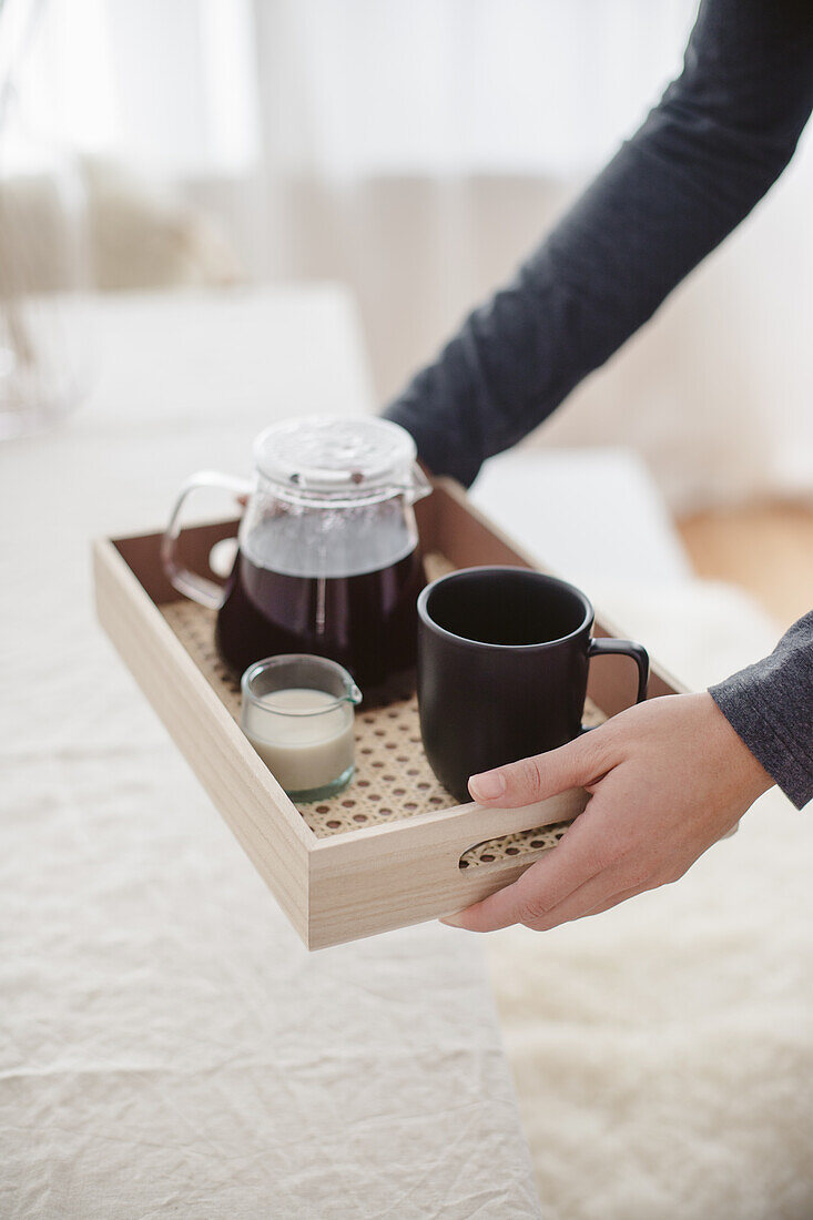 A pot of tea, mug and milk on DIY tray with Viennese cane base