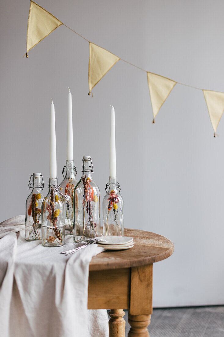 DIY candle holder made from glass bottles with dried flowers