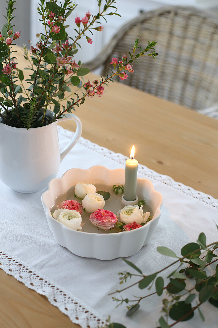 Schale mit Kerze und Ranunkeln, Strauß aus Waxflower, Eukalyptus