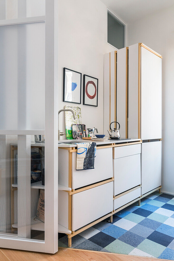 Simple kitchenette on a blue checkered tile floor