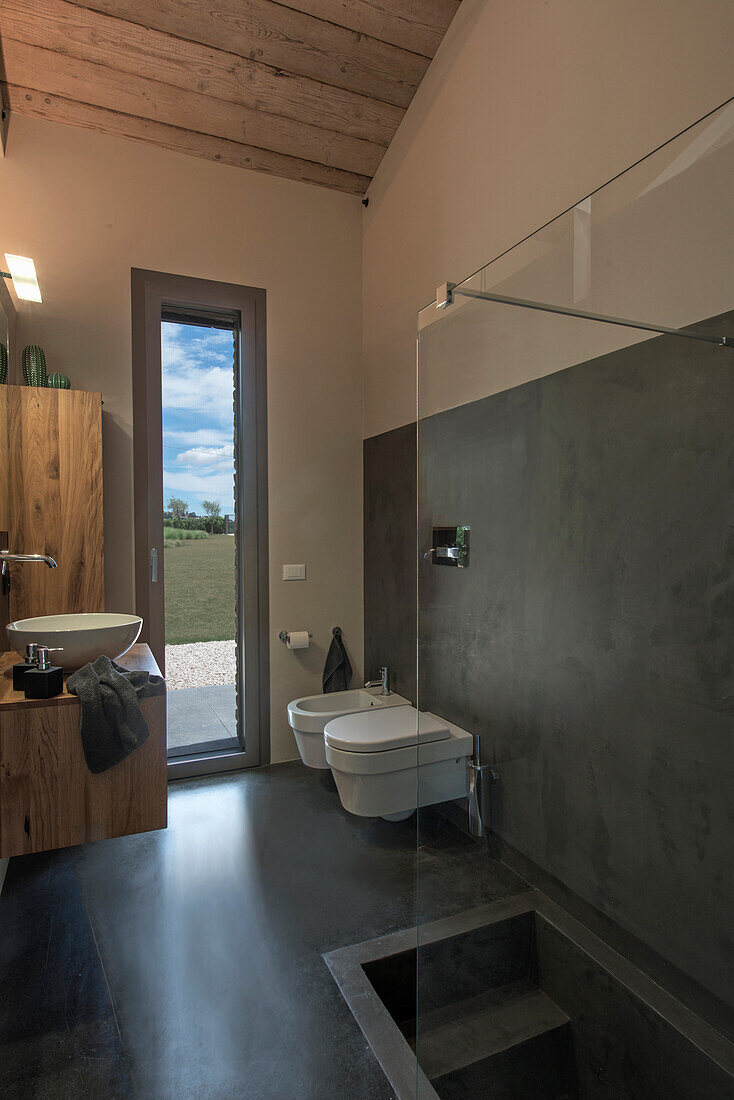 Badezimmer mit Holz-, Beton- und Glaselementen