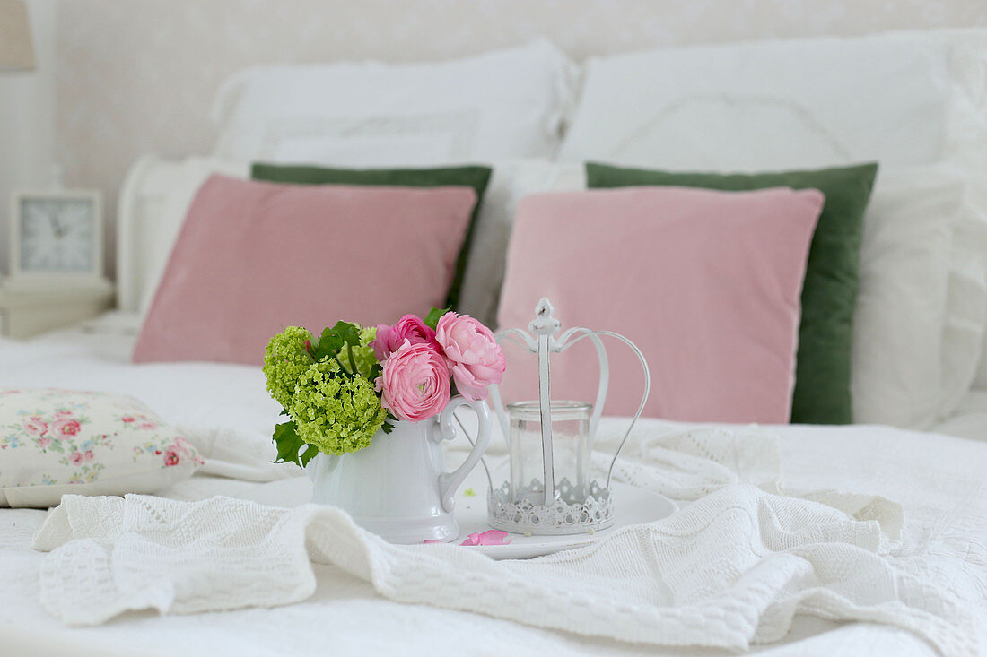 Tray with flowers on double bed with white blanket