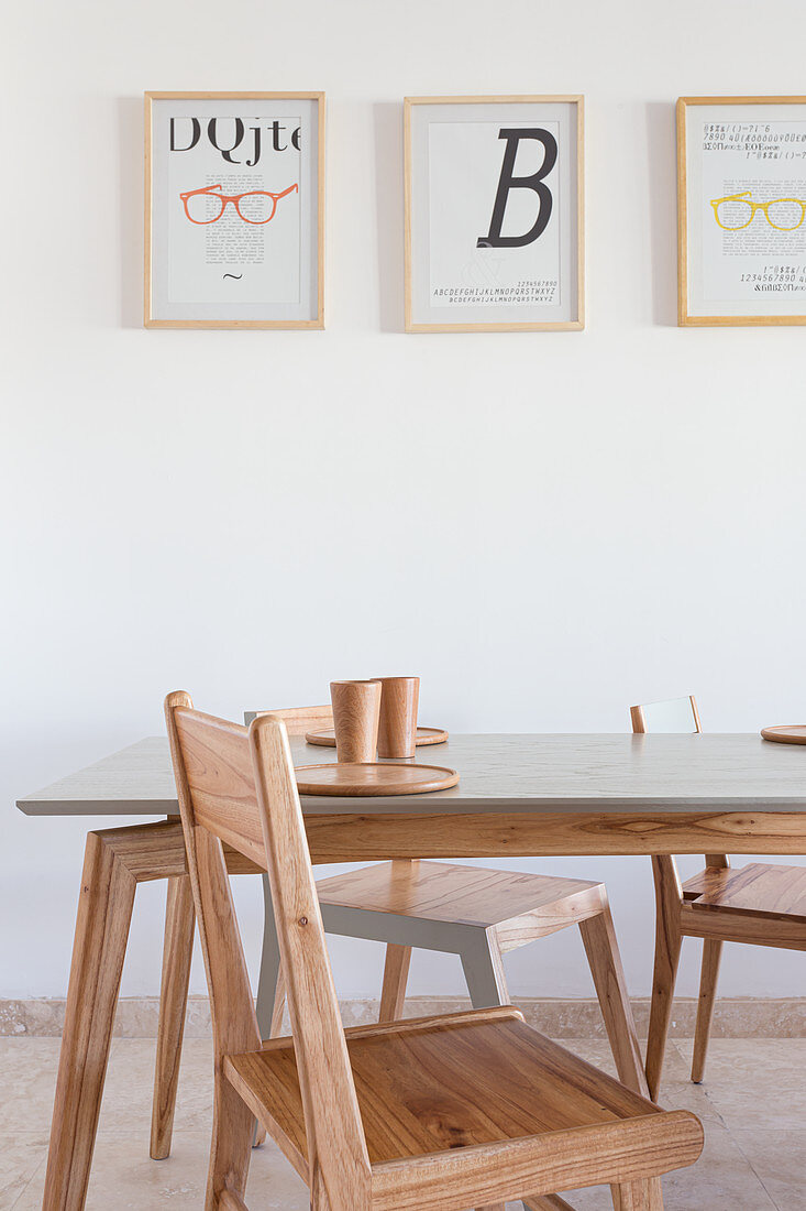 Designer Stühle und Esstisch und moderne Drucke an der Wand