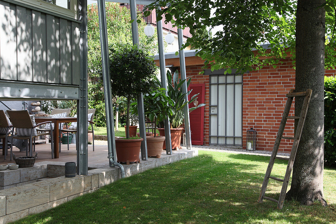Terrasse mit Überdachung und Kübelplflanzen, Rasen mit Lindenbaum