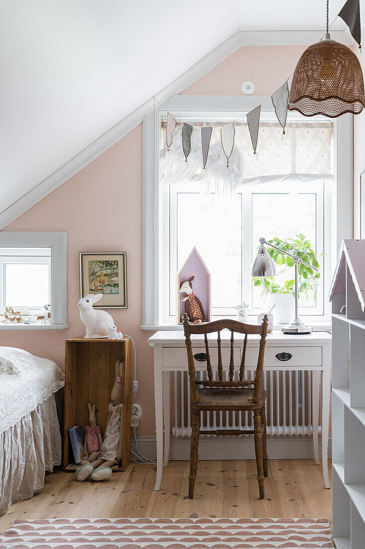 Girls' room with a pink wall in country style in the attic