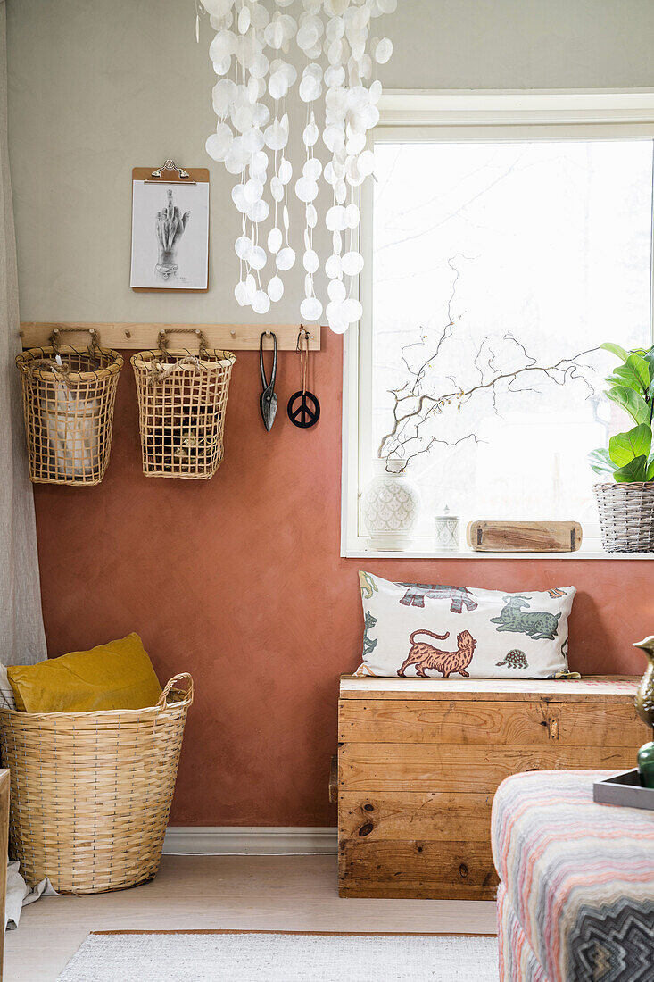 Baskets on a wooden rail and wooden chest under the window in the living room