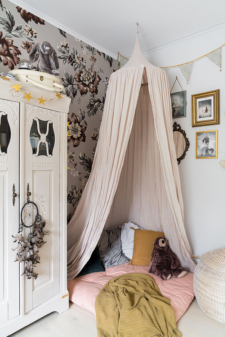 Cozy corner with canopy and antique wardrobe in a girl's room