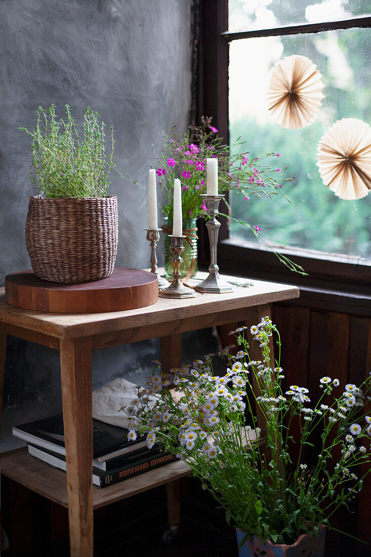 Meadow bouquets made from Carthusian carnation with grasses and annual fine stream, basket with thyme on a wooden disc and silver candle holders