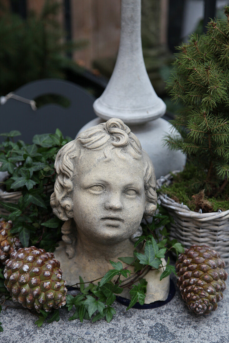 Arrangement of pinecones, ivy and bust