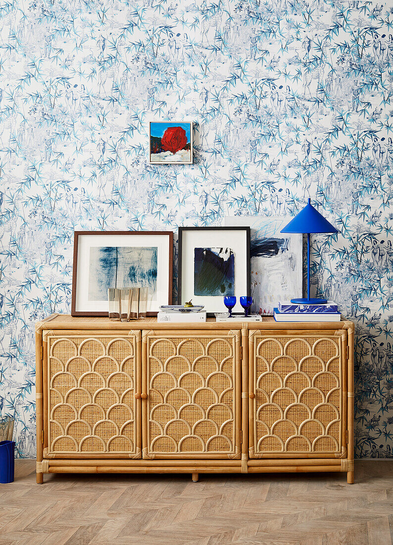 Small cabinet against wall with blue and white wallpaper