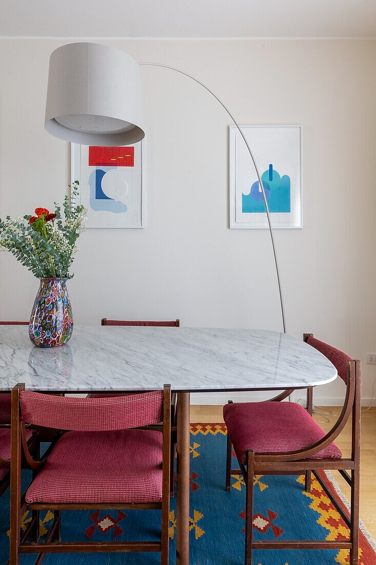 Bogenlampe über Esstisch mit Marmorplatte und gepolsterte Stühle
