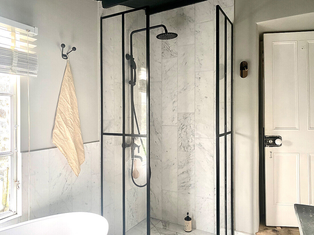 Duschbereich mit Verglasung und schwarzen Armaturen