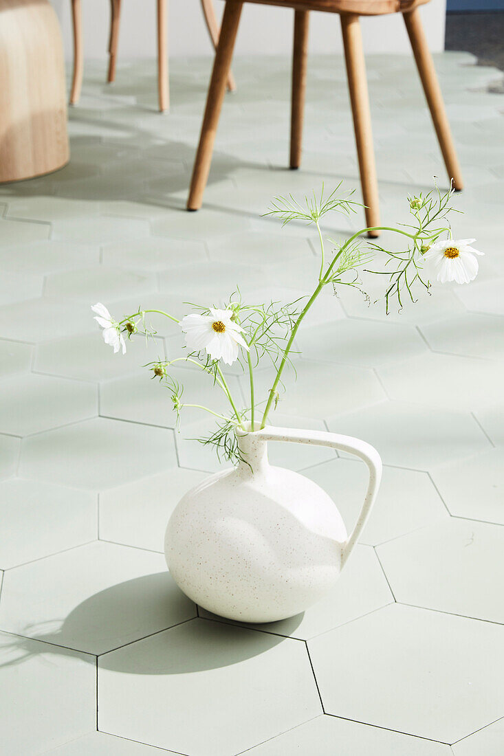 Vase with cosmea on honeycomb tiles