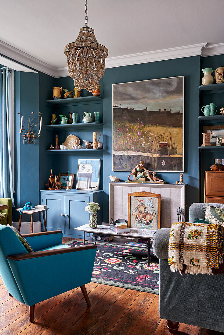 Farbenfrohe Sammlung von Vasen und Krügen auf maßgefertigten Regalen im Wohnzimmer mit blauen Wänden