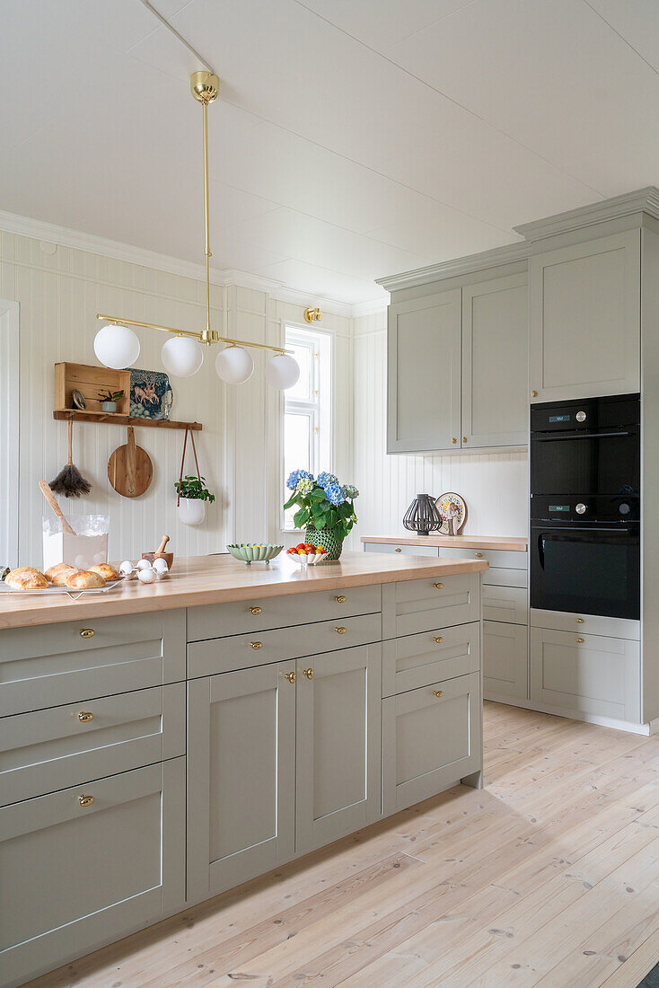 Classic kitchen with grey coffered cabinet fronts and wooden floorboards
