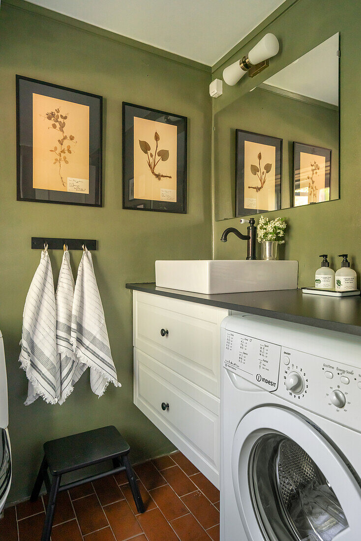 Kleines Badezimmer mit grünen Wänden und botanischen Bildern