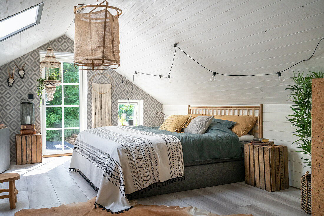 Queen sized bed in bohemian styled bedroom with a gable roof