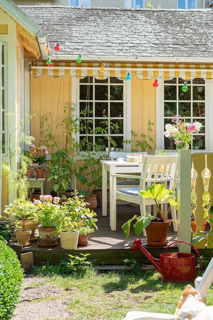 Sunny terrace with seating outside yellow Swedish house