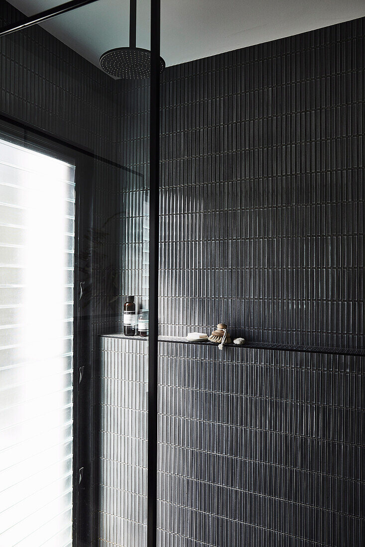 Shower area with black wall tiles