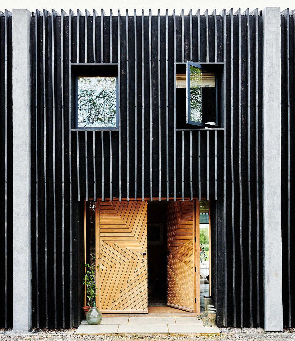 Schwarze Fassade mit Holztüren