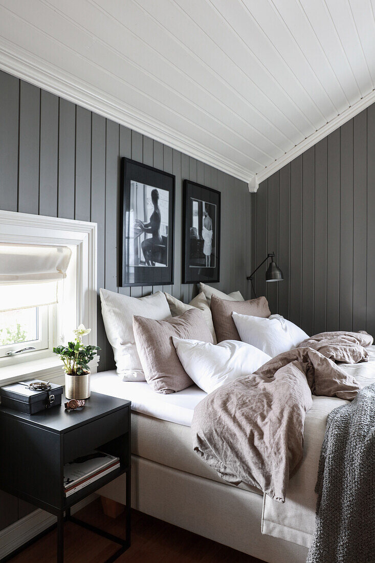 Double bed in bedroom with grey-painted wood panelling