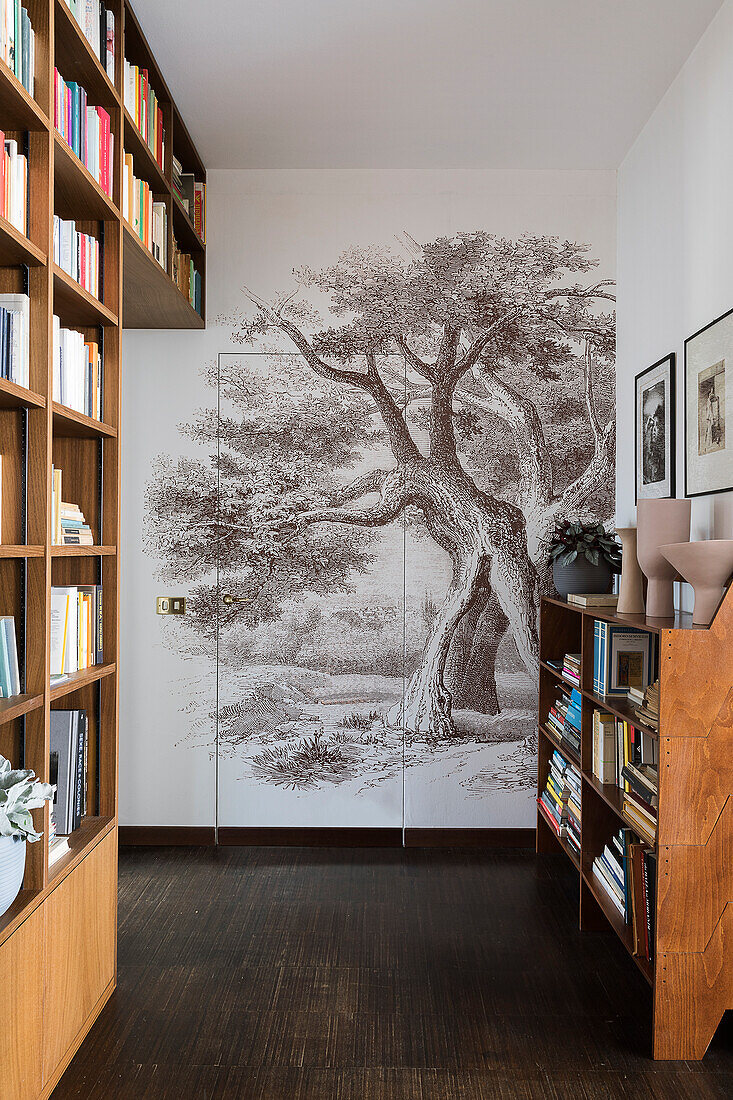 Raumhohes Bücherregal und Tapete mit Baummotiv auf dem Flur