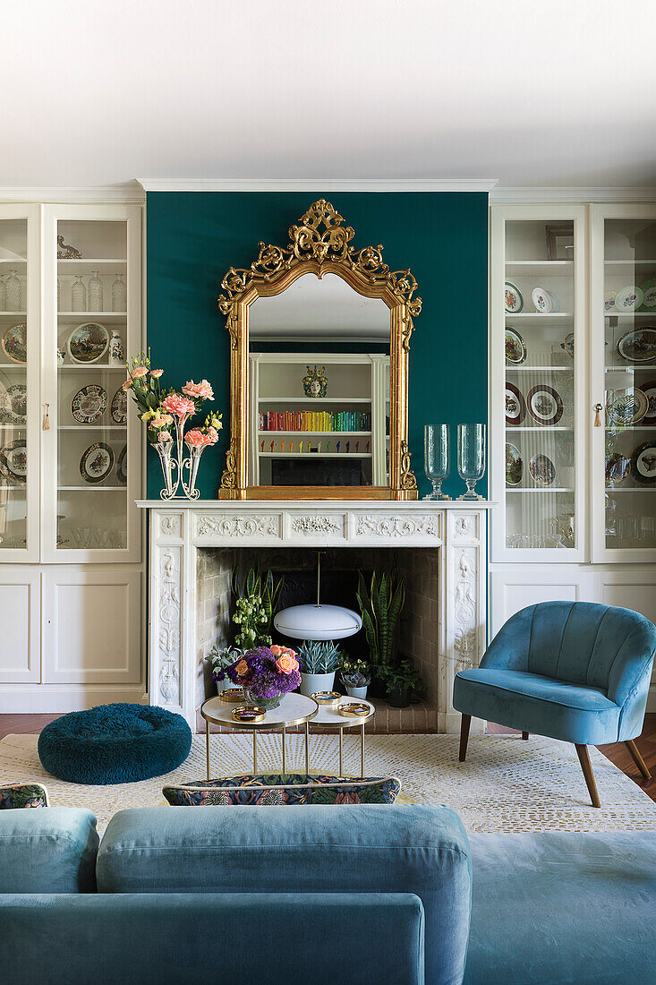 Elegant seating area with upholstered furniture and fireplace flanked by display cabinets