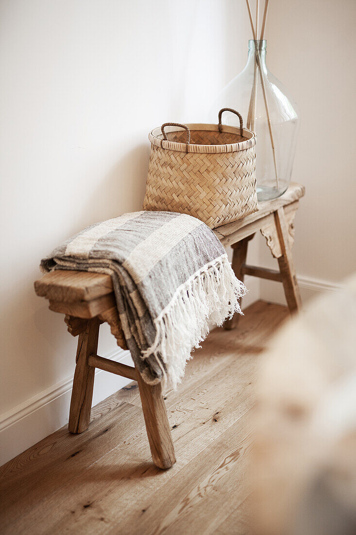 Wooden bench with blanket and basket bag