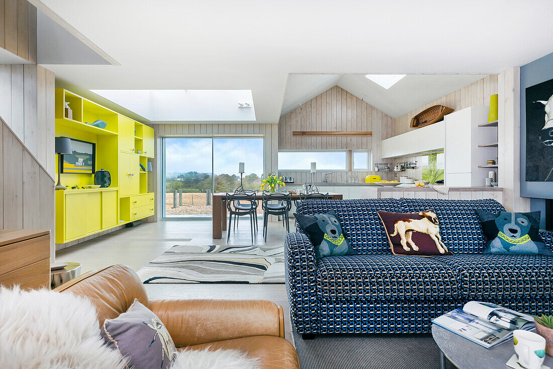 Offener Wohnraum mit Lounge, im Hintergrund grün-gelbe Wohnwand