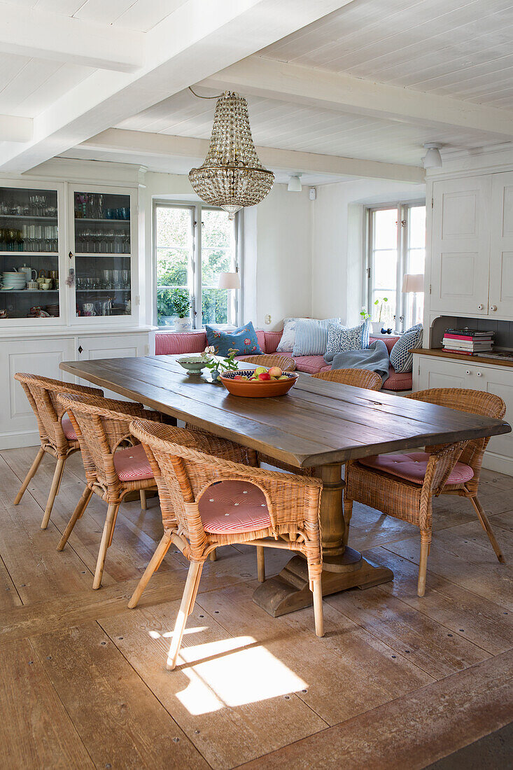 Dining area with solid wood table and rattan chairs in spacious eat-in kitchen