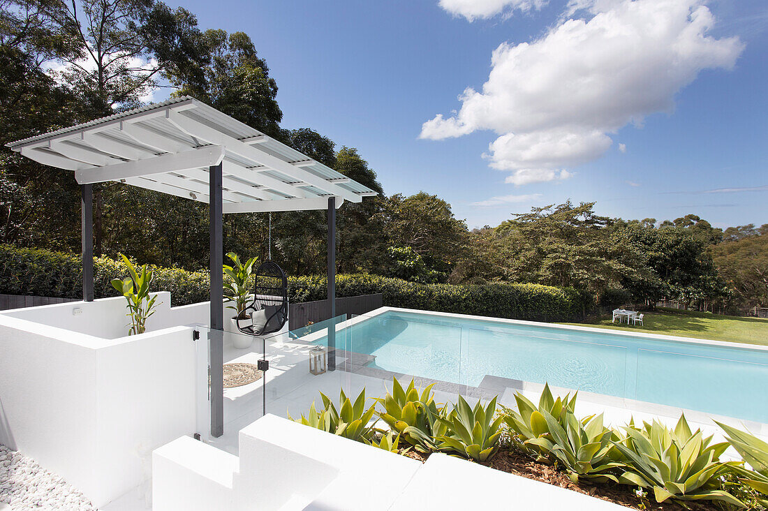 Blick auf weiße Terrasse mit Überdachung und Pool