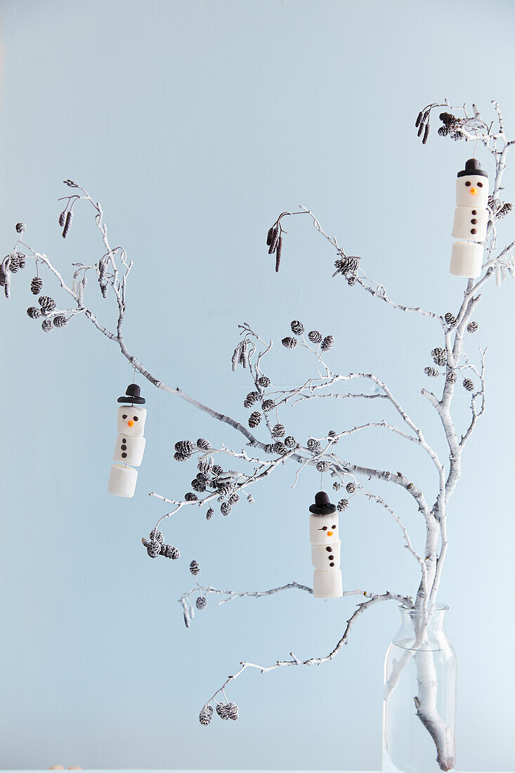 Weihnachtsdekoration mit Lärchenzweigen und DIY-Schneemännern aus Marshmallows