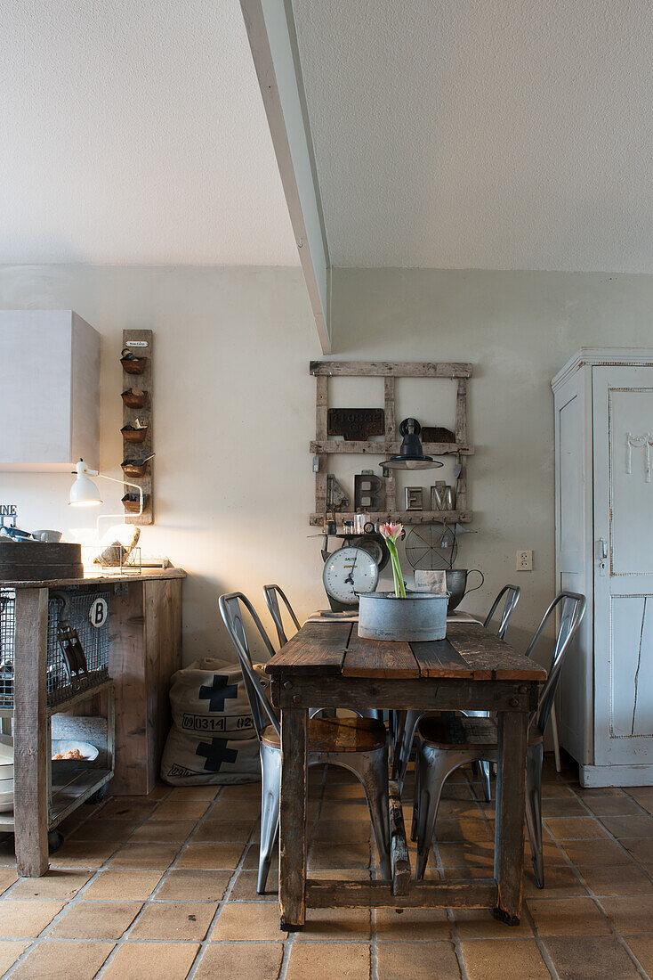 Alter Holztisch mit Metallstühlen vor Kücheninsel