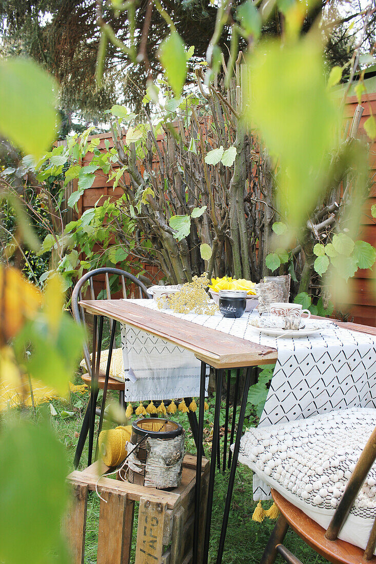 Gartentisch mit Dekos aus Birkenrinde und Holzkiste