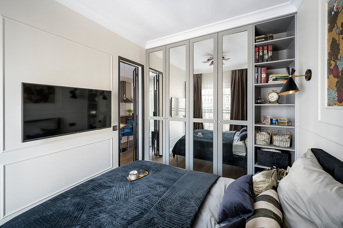 Double bed, fitted wardrobes with mirrored doors and TV on the wall in bedroom