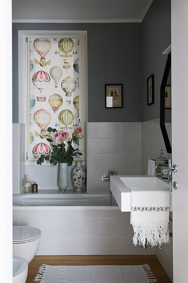 Badezimmer mit grauen Wänden und Vorhang mit Heißluftballon-Motiv