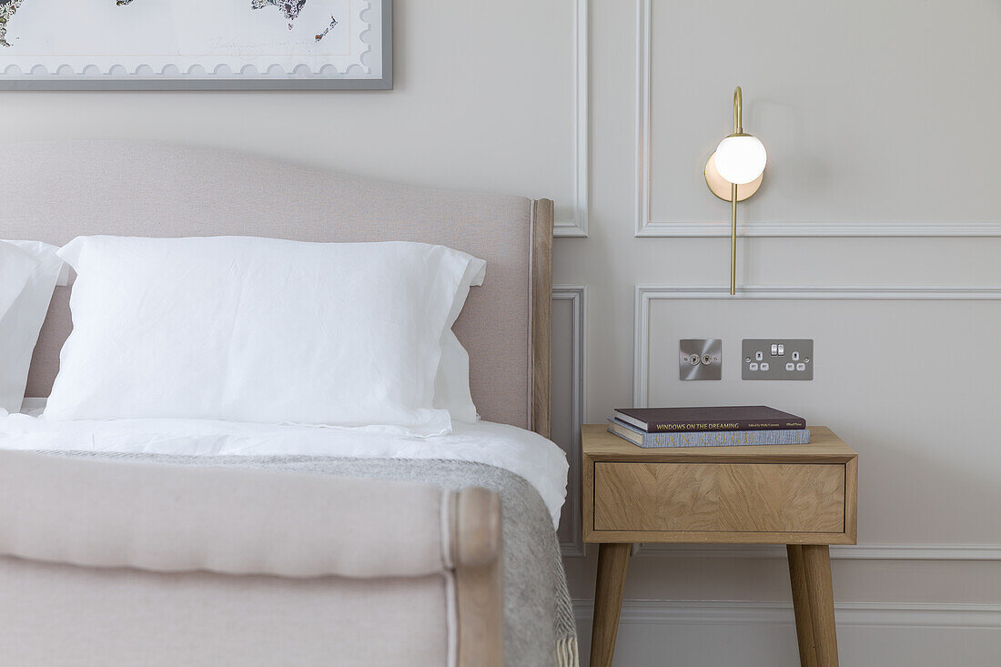 Double bed and bedside table in elegant bedroom in beige tones