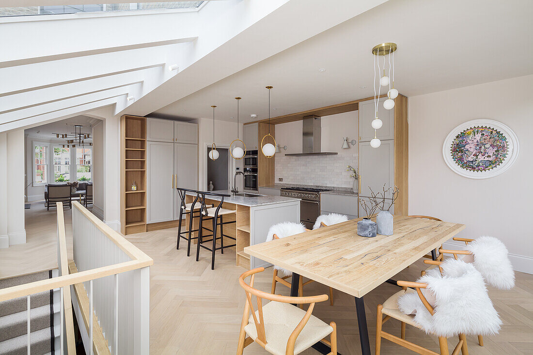 Dining area and kitchen in open-plan interior with skylights