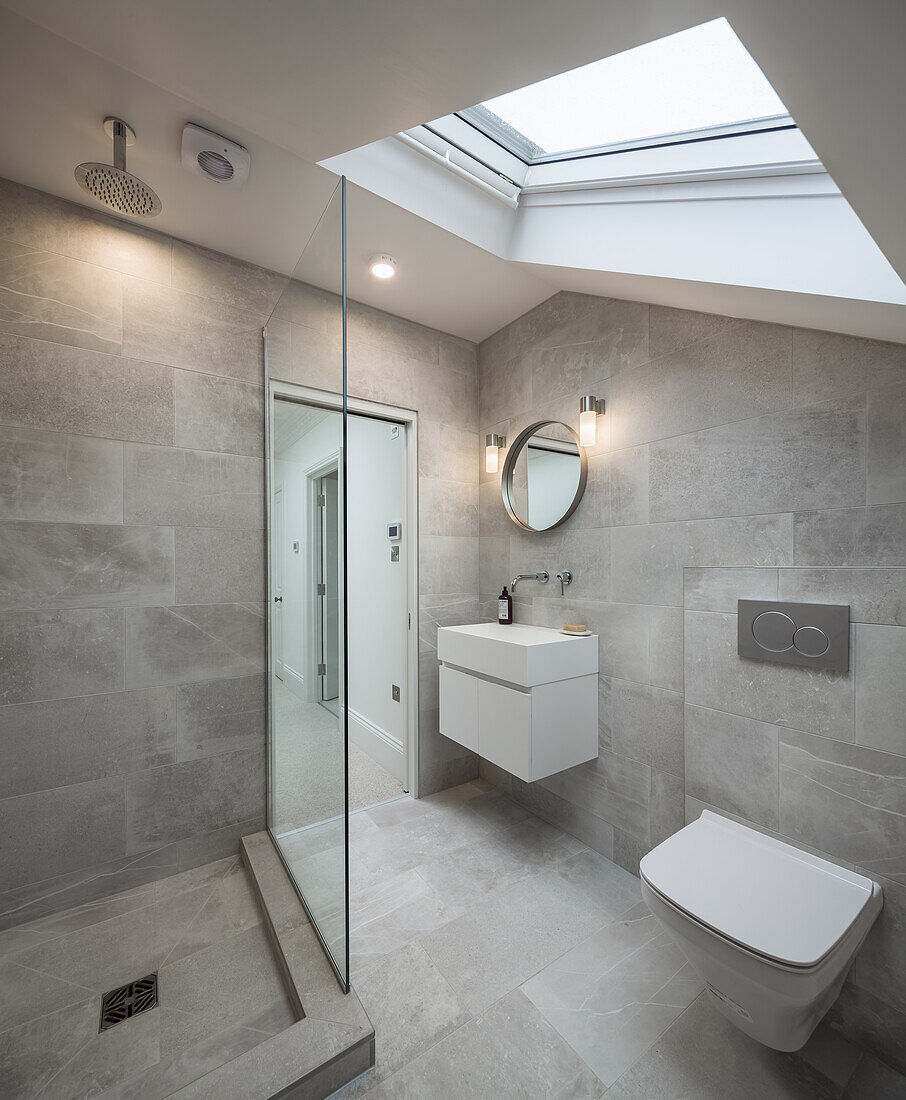 Schlichtes Badezimmer mit Dusche, Betonfliesen und Oberlichtfenster