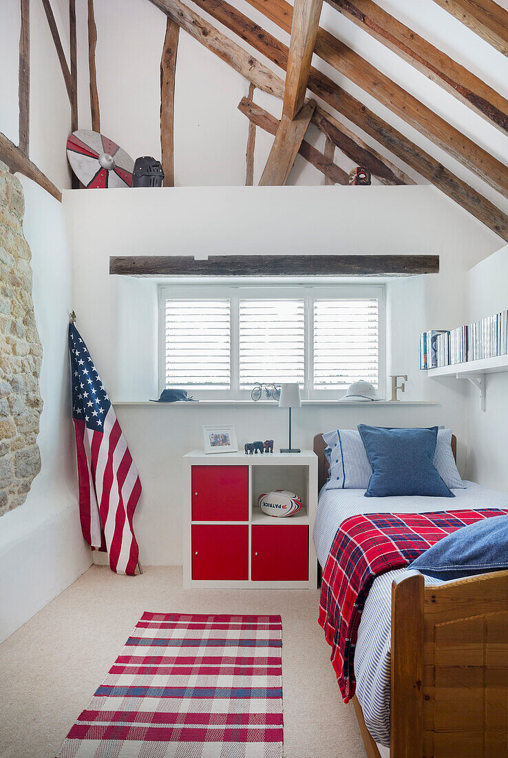 Jungenzimmer mit rot-weiß-blauem Farbkonzept in umgebauter Scheune