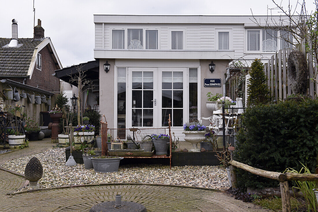 Modernes Haus mit gepflastertem Garten und nostalgischer Deko