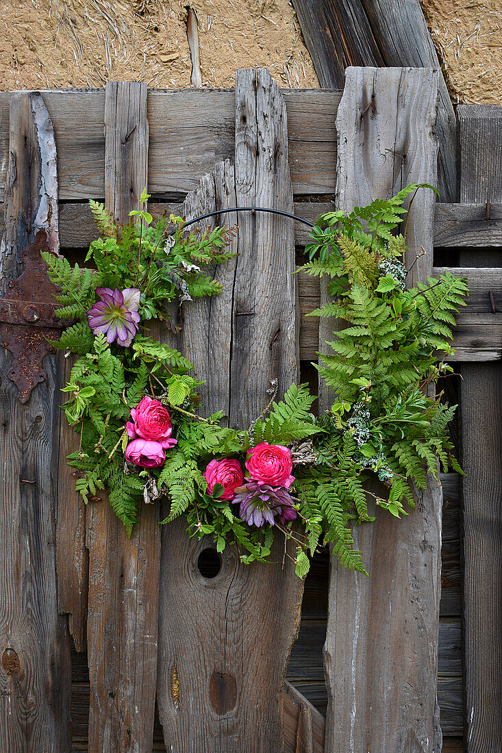 Fern wreath with ranunculus blossoms and lentil rose