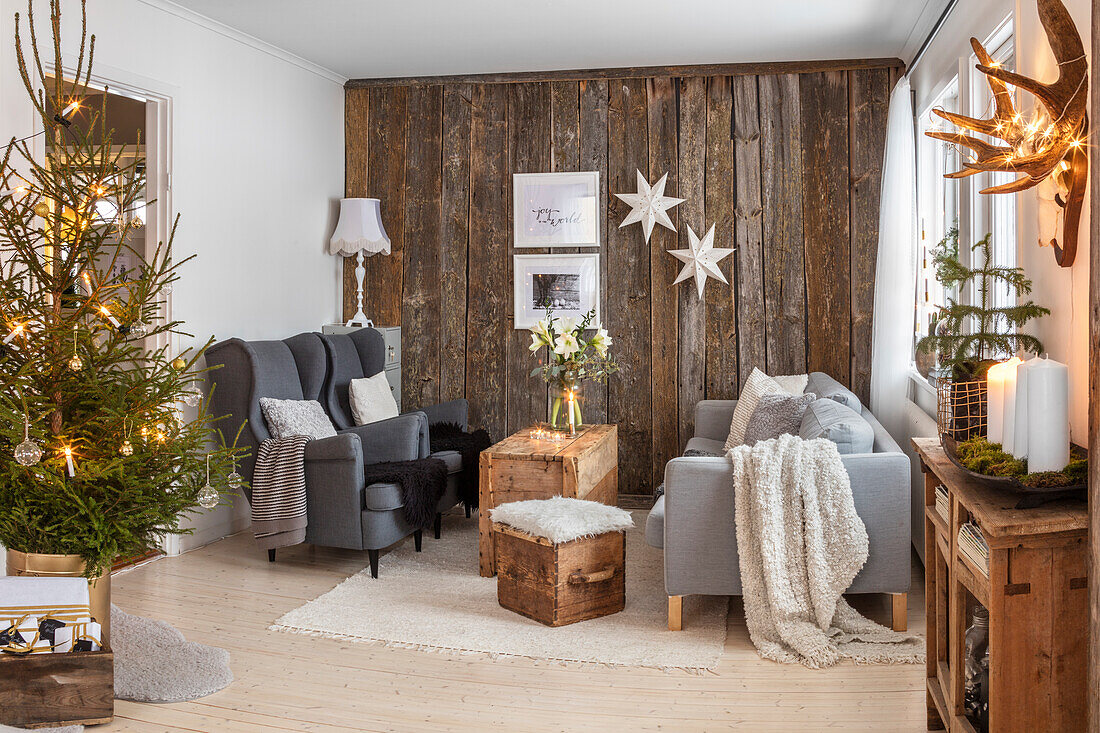 Living room decorated for Christmas with wooden accent wall and Christmas tree
