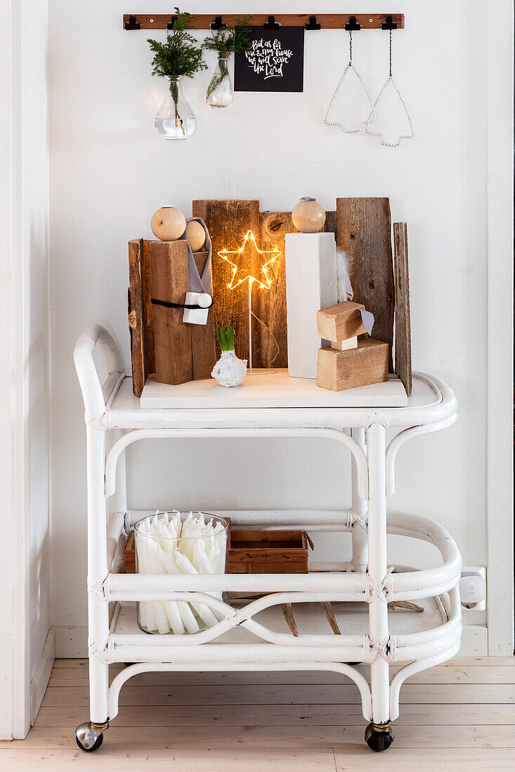 Serving trolley decorated for Christmas, above it a strip with metal clips and Christmas decorations