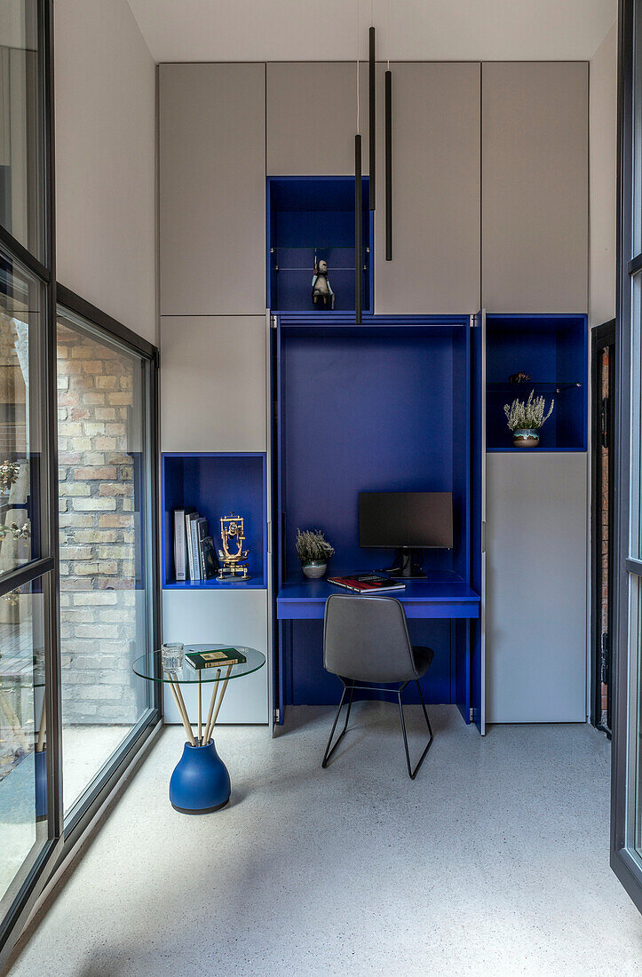 Work area with integrated desk and cabinets in grey and blue