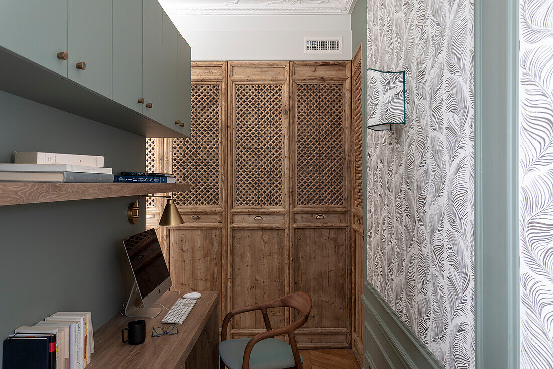 Home office with desk, wardrobe and patterned wallpaper